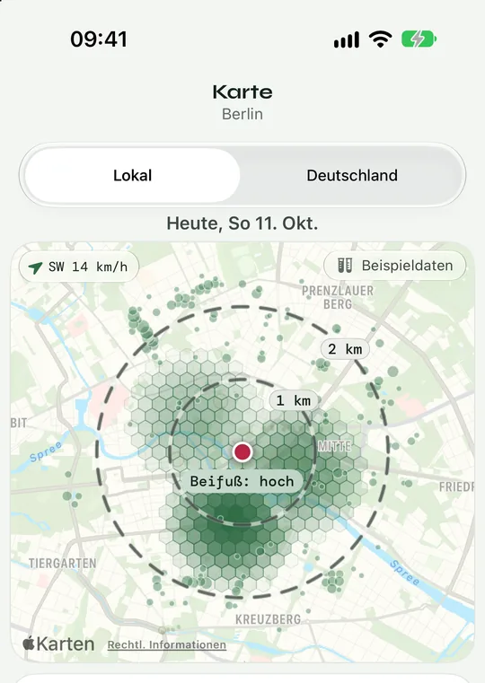Karte Lokal in der App Pollenradar: grüne Sechsecke zeigen, wo rund um einen Standort in Berlin viele Pollenquellen liegen, dazu Ringe bei 1 und 2 Kilometern und ein Windpfeil aus Südwest. Beispieldaten.
